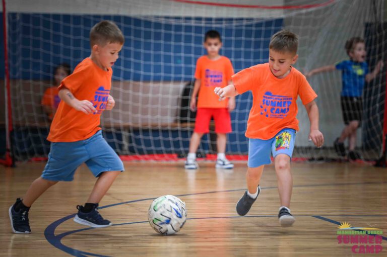 boys playing soccer on a basketball court